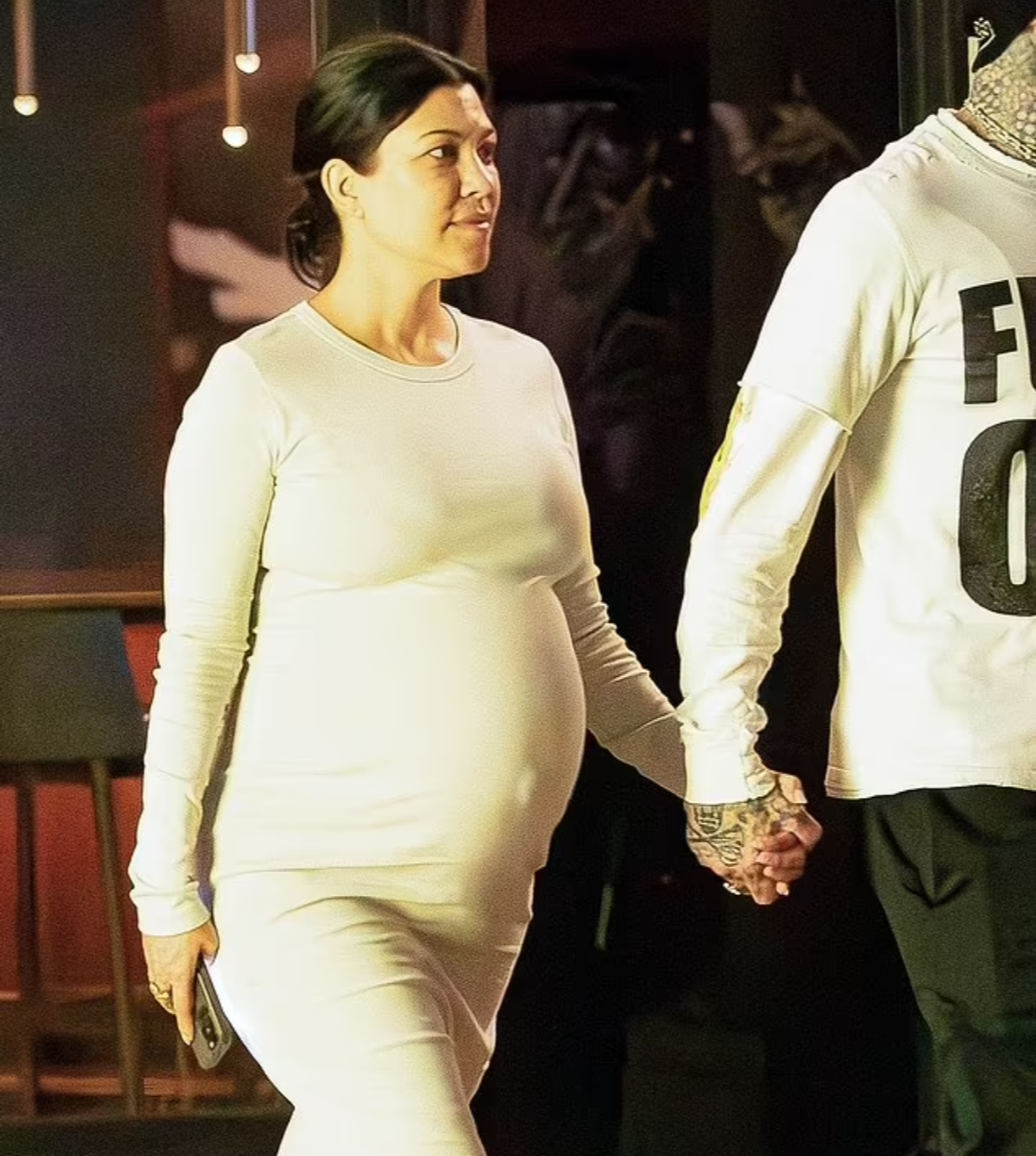 Kourtney Kardashian shows off her huge baby bump while holding hands with Travis Barker after vegan dinner date (photos)