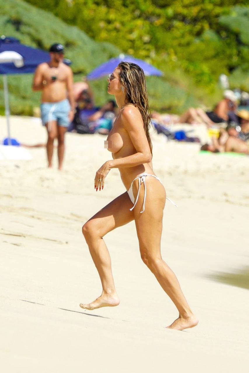 50-year-old Heidi Klum goes topless in just bikini as she makes out with husband on the beach (photos)