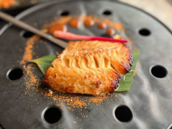 Customers show the size of fish they were charged N87k for at a Japanese restaurant in Lagos
